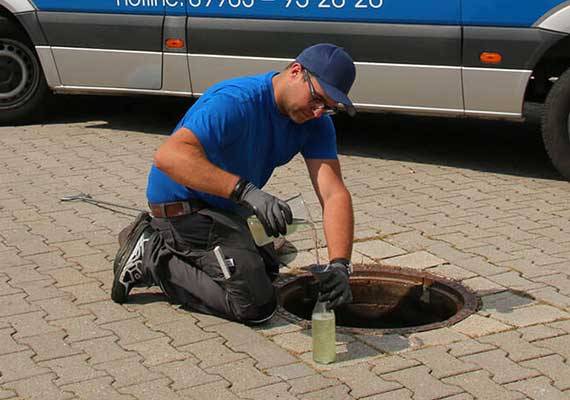 Monteur bei monatlicher Kontrolle eines Ölabscheiders